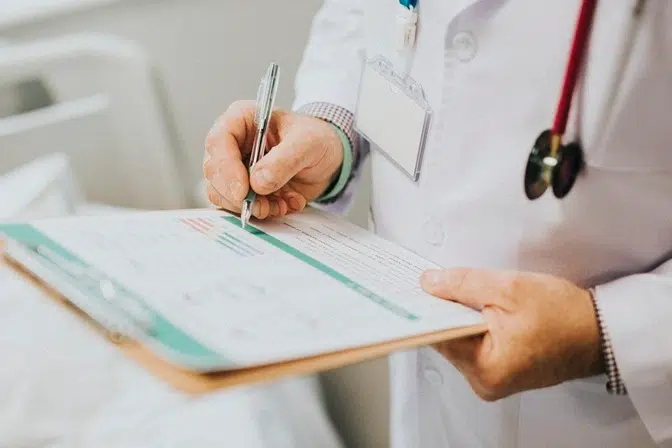 Online Tele Psychiatry in California physician noting down symptoms patient
